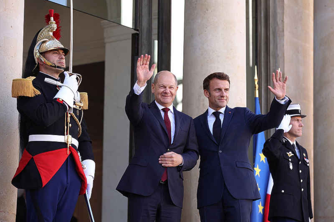 Macron, Scholz plaster over differences with smiles and a handshake